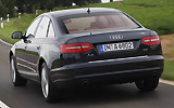 Audi A6. Modelo 2009. Imagen. Berlina. Lateral posterior. Coche en movimiento. Carretera.