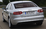 Audi A6. Modelo 2009. Imagen. Berlina. Lateral posterior. Coche en movimiento. Carretera. Gris.