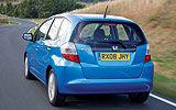 Honda Jazz. Modelo 2009. Imagen. Lateral- posterior. Coche en movimiento. Carretera. Azul.