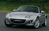 Mazda MX-5. Modelo 2009. Imagen. Frontal- lateral. Coche parado. Descapotado. Carretera. Gris