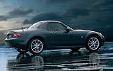 Mazda MX-5. Roadster Coup�. Modelo 2009. Imagen. Lateral. Coche parado. Techo met�lico plegable. Carretera. Gris oscuro.