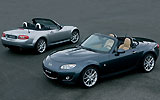 Mazda MX-5. Modelo 2009. Imagen. Lateral- cenital- frontal. Coche parado. Descapotado. Carretera. Gris. Gris oscuro.