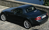Mazda MX-5. Roadster Coup&eacute;. Modelo 2009. Imagen exterior. Lateral posterior. Coche parado. Carretera. Gris.