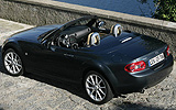 Mazda MX-5. Roadster Coup&eacute;. Modelo 2009. Imagen exterior. Lateral posterior cenital. Coche parado. Carretera. Gris.