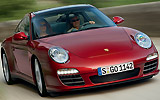 Porsche 911 Targa. Modelo 2009. Imagen. Lateral frontal. Techo acristalado. Coche en movimiento. Carretera. Rojo rub� metalizado. 