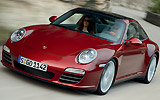 Porsche 911 Targa. Modelo 2009. Imagen. Frontal lateral. Techo acristalado. Coche en movimiento. Carretera. Rojo rub� metalizado. 