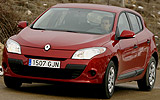Renault Megane. Modelo 2009. Imagen. 5 puertas. Frontal lateral. Coche en movimiento. Carretera. Rojo.