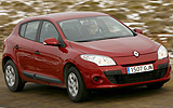 Renault Megane. Modelo 2009. Imagen. 5 puertas. Lateral frontal. Coche en movimiento. Carretera. Rojo.