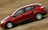 Renault Megane. Modelo 2009. Imagen. 5 puertas. Lateral. Coche en movimiento. Carretera. Rojo.